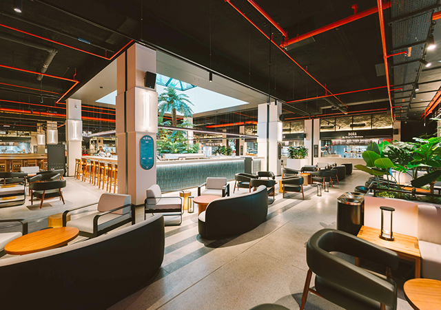 The design establishes a clear hierarchy of light, featuring ambient illumination for comfort and conviviality, accent lighting to highlight key features, and feature lighting that reinforces the Time Out Market brand.
